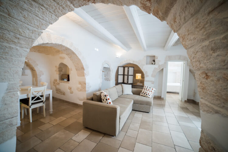The inside of a Trullo House with rustic arches and stone floors.