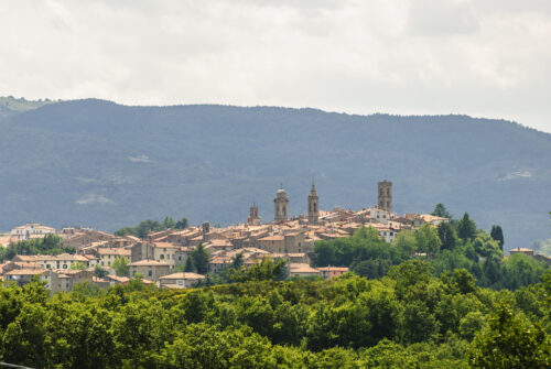 Panoramic view of Castel del Piano in Tuscany, a town with typical red roofed houses, sitting amidst trees and small hills