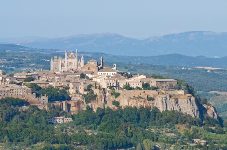 Panoramic view of Orvieto, Umbria, Italy, taken from a distance, with the cathedral facade clearly visible, built of a rocky outcrop.
