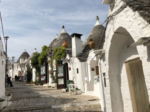 Street in Alberobello, Trulli houses in Puglia. The houses are typical of Trulli, all white washed with intricate tiled roofs