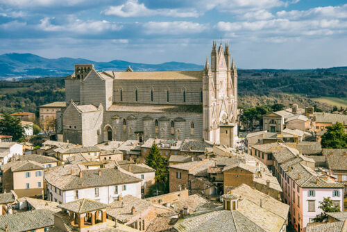 At the centre of Orvieto, the piazza opens out beneath the cathedral, surrounded by rooftops and rolling countryside beyond.