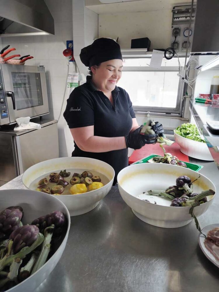 Happy staff prepping local plot-to-plate food in a restaurant in Puglia