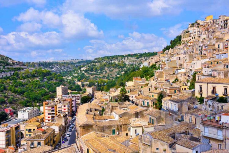 Rows of stone houses stack along the hillside in Modica, showing the layered streets and rooftops that shape the town’s historic centre.